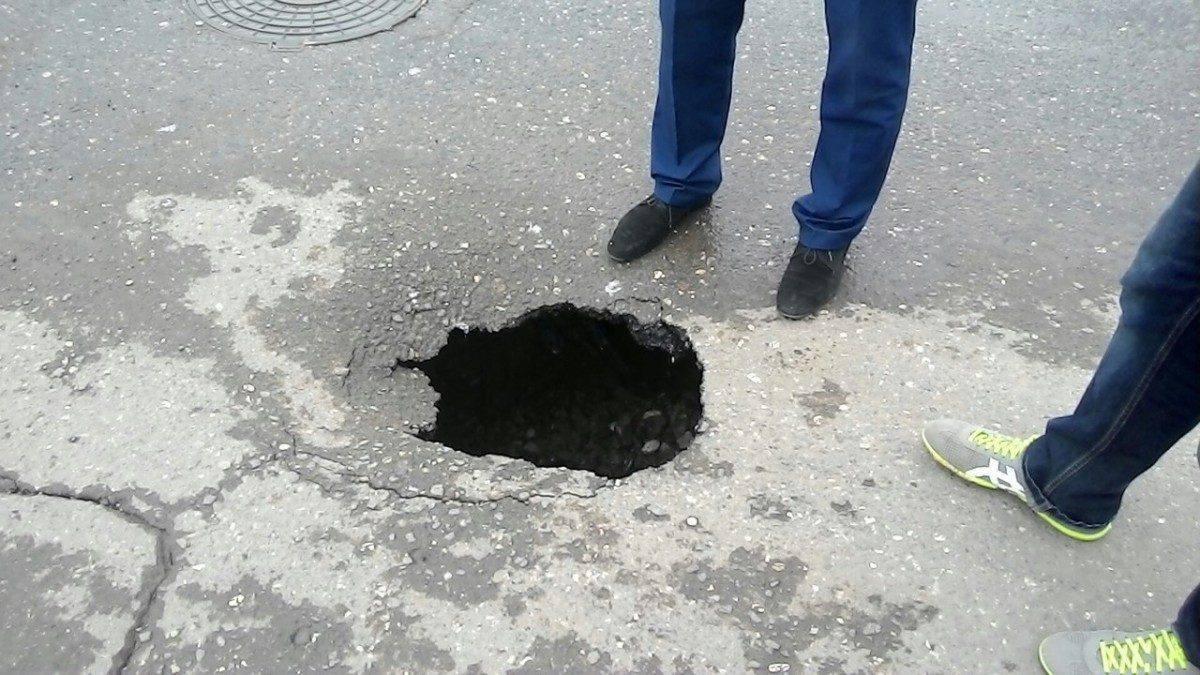 Люди огородили собой очередную яму в Астрахани