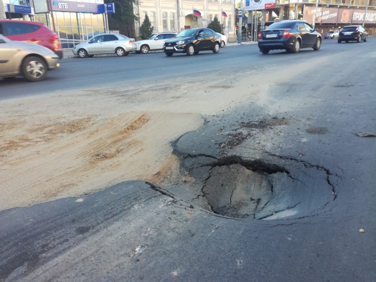 В центре Астрахани на свежеотремонтированной дороге машина провалилась в яму