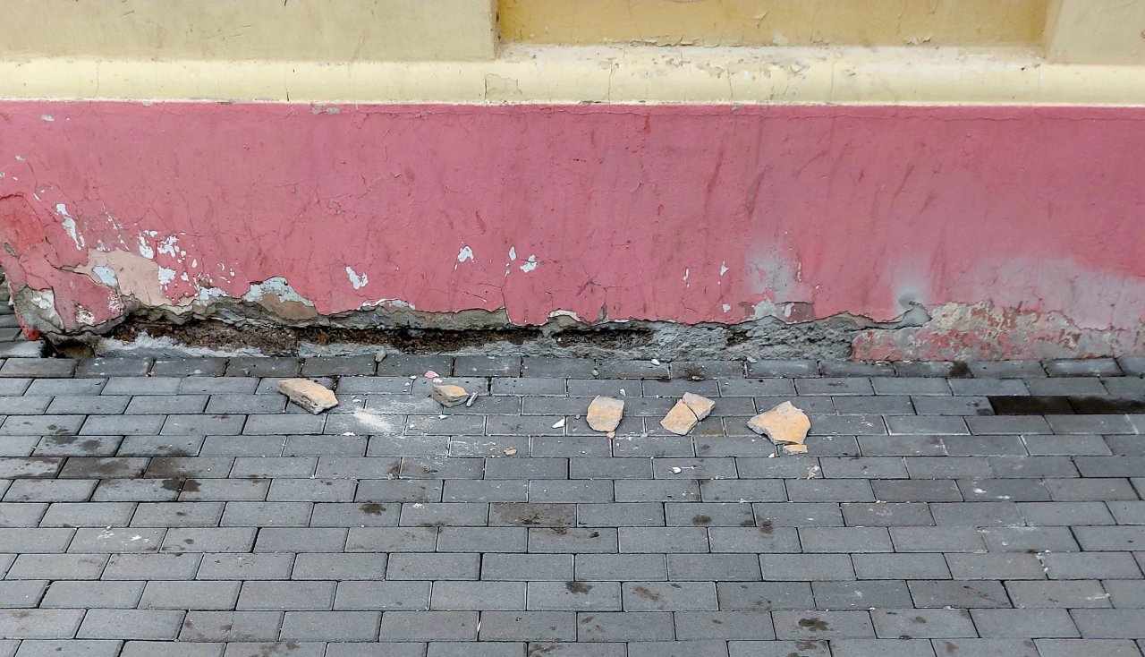 С дома в центре Астрахани на тротуар падает штукатурка