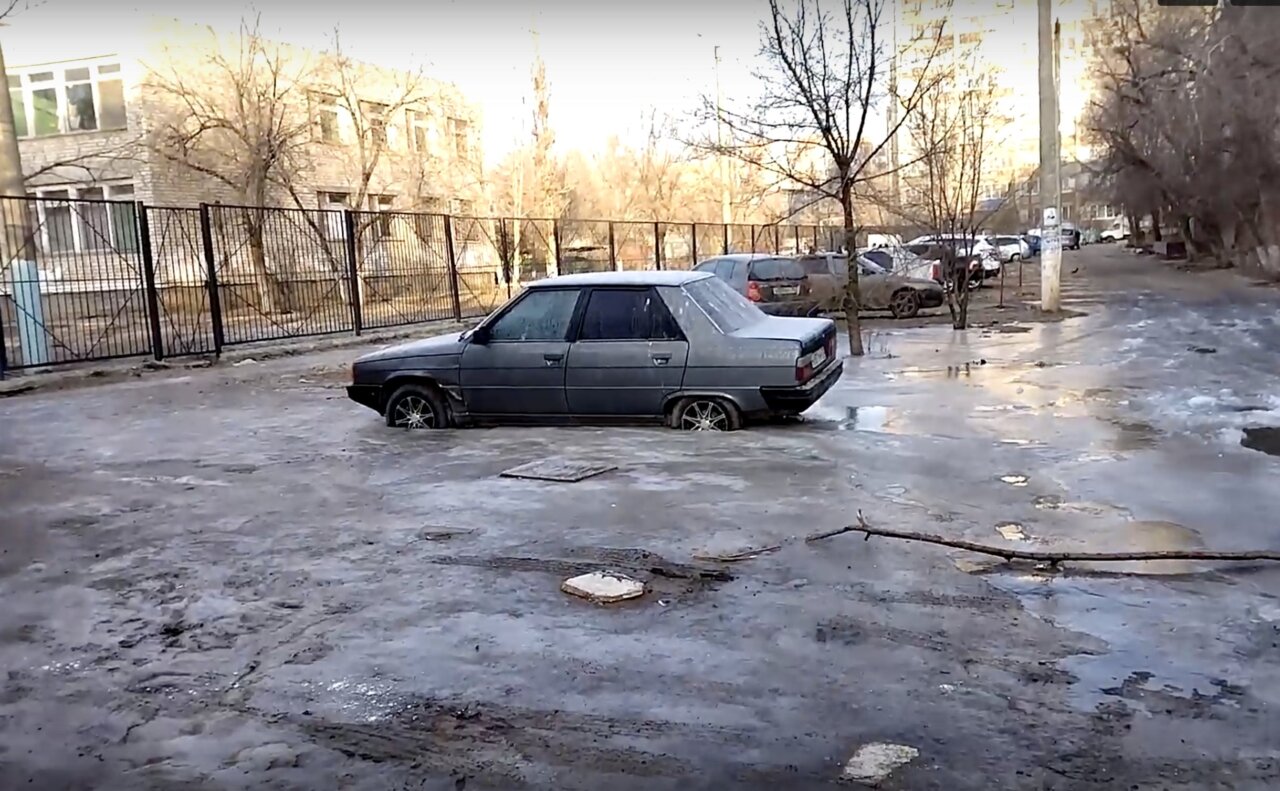 Припаркованная в астраханском дворе машина вмерзла в лед после коммунальной аварии