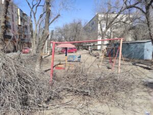 В Астрахани дети вынуждены играть на площадке в окружении собак, мусора, спиленных деревьев и гаражей
