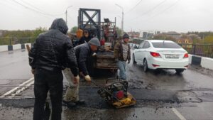 На Старом мосту заделали большую яму, несмотря на дождь