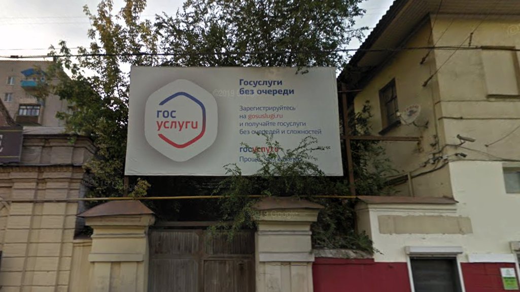 В Астрахани убирают рекламный щит, 13 лет висевший над памятником архитектуры